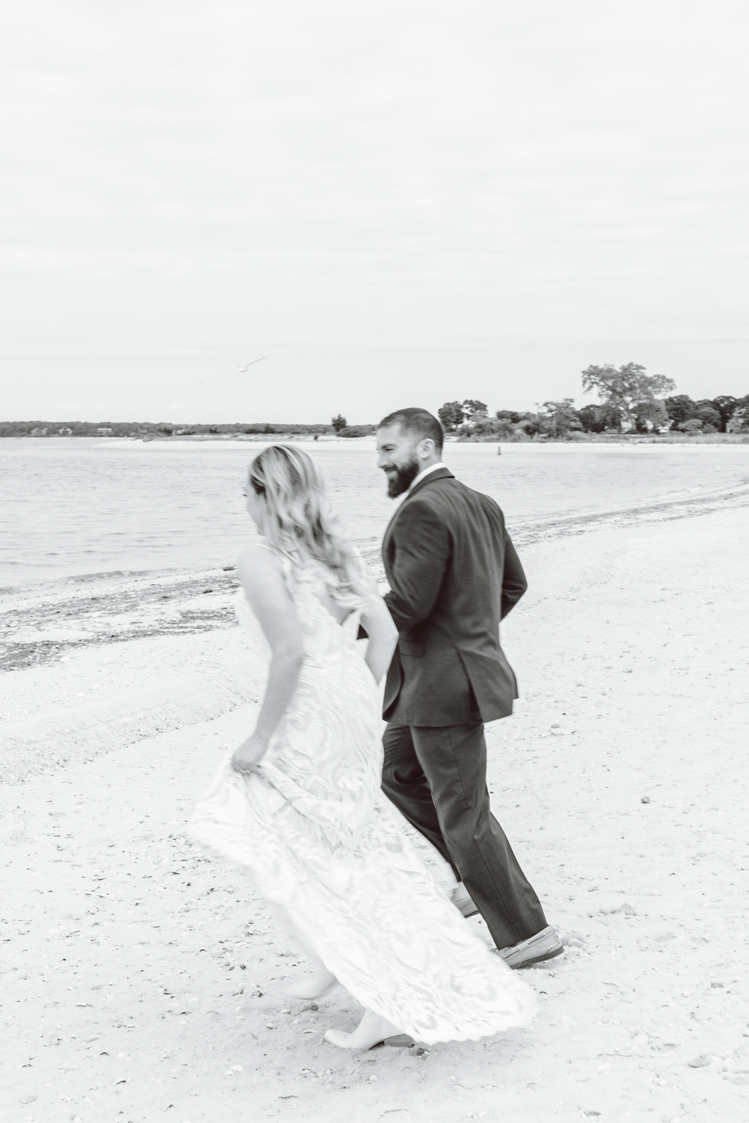 Bride and groom holding hands and running on beach | Brooke Michelle Photography