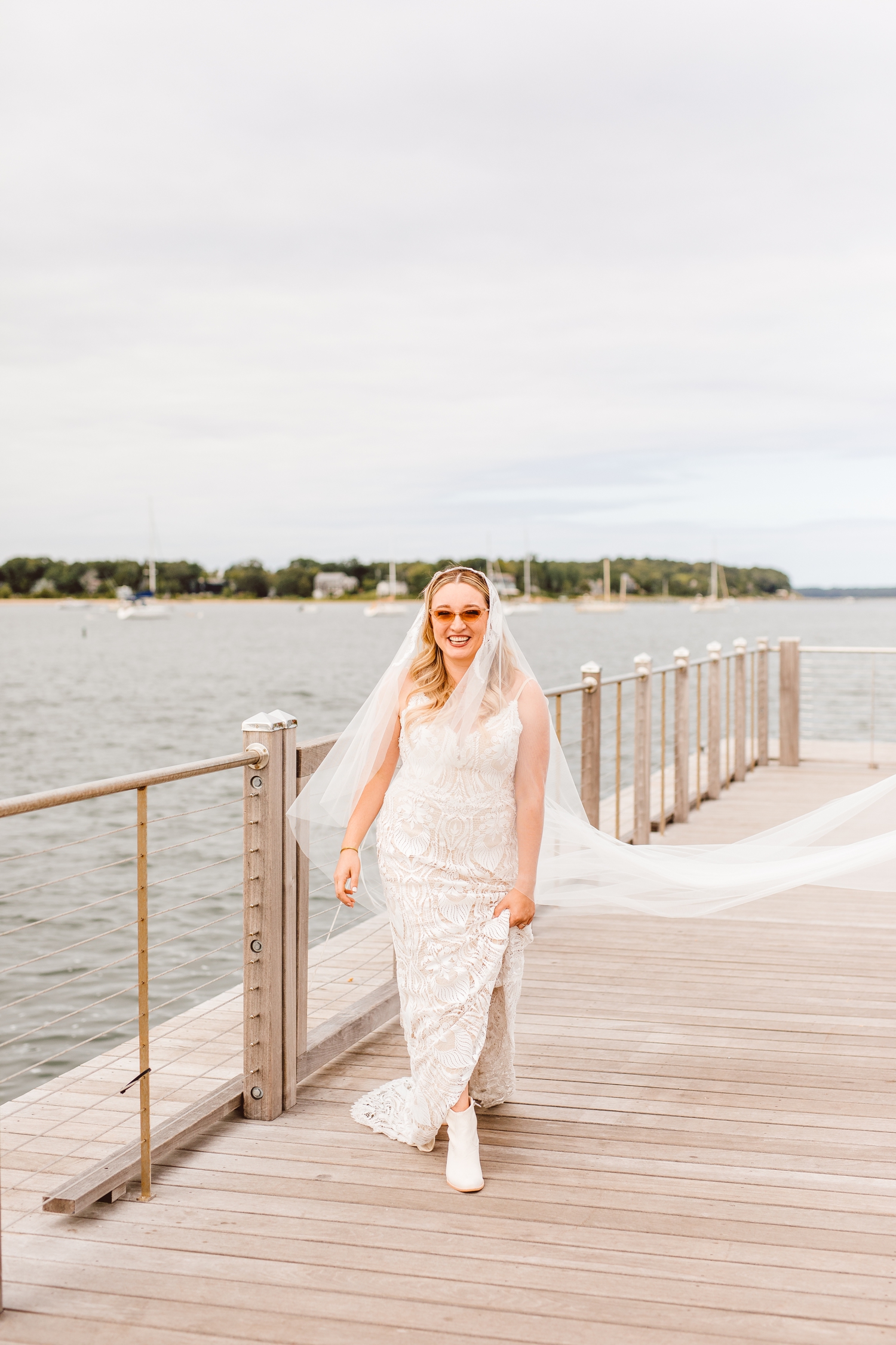 Bride wearing cat eye sunglasses and walking on pier | Brooke Michelle Photography