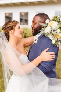 Bride and groom looking at each other with veil blowing in wind | Brooke Michelle Photography