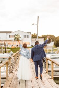 Bride and groom walking away with fists raised in the air | Brooke Michelle Photography