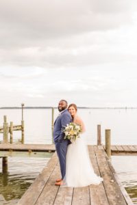 Bride standing behind groom on dock at Wylder Hotel Tilghman Island | Brooke Michelle Photography