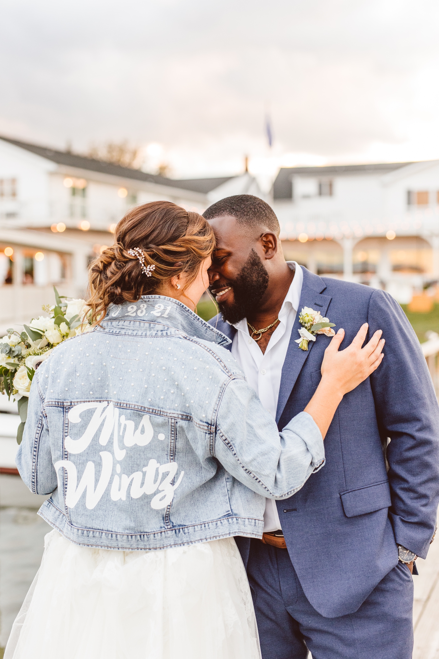 Bride and groom looking at each other with bride wearing jean jacket with married name | Brooke Michelle Photography