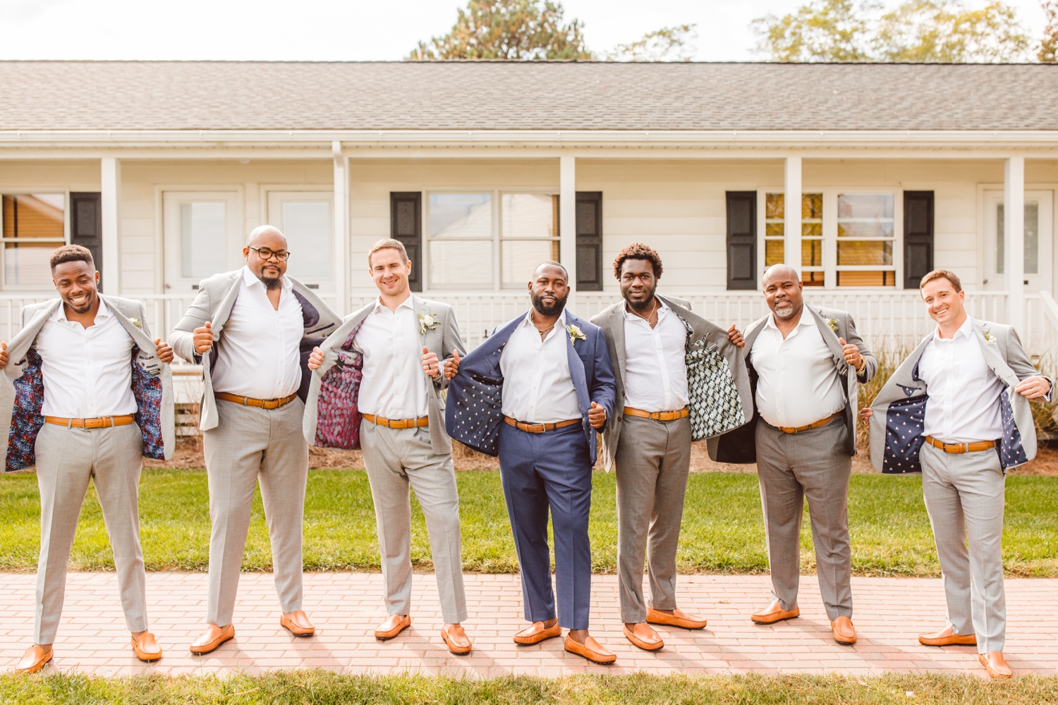 Groom and groomsmen showing patterns inside of suit packets | Brooke Michelle Photography