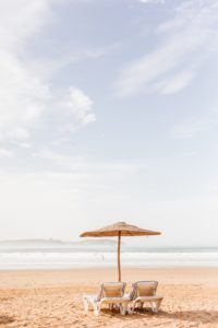 Two beach chairs under a straw umbrella in Marrakesh, Morocco | Brooke Michelle Photography