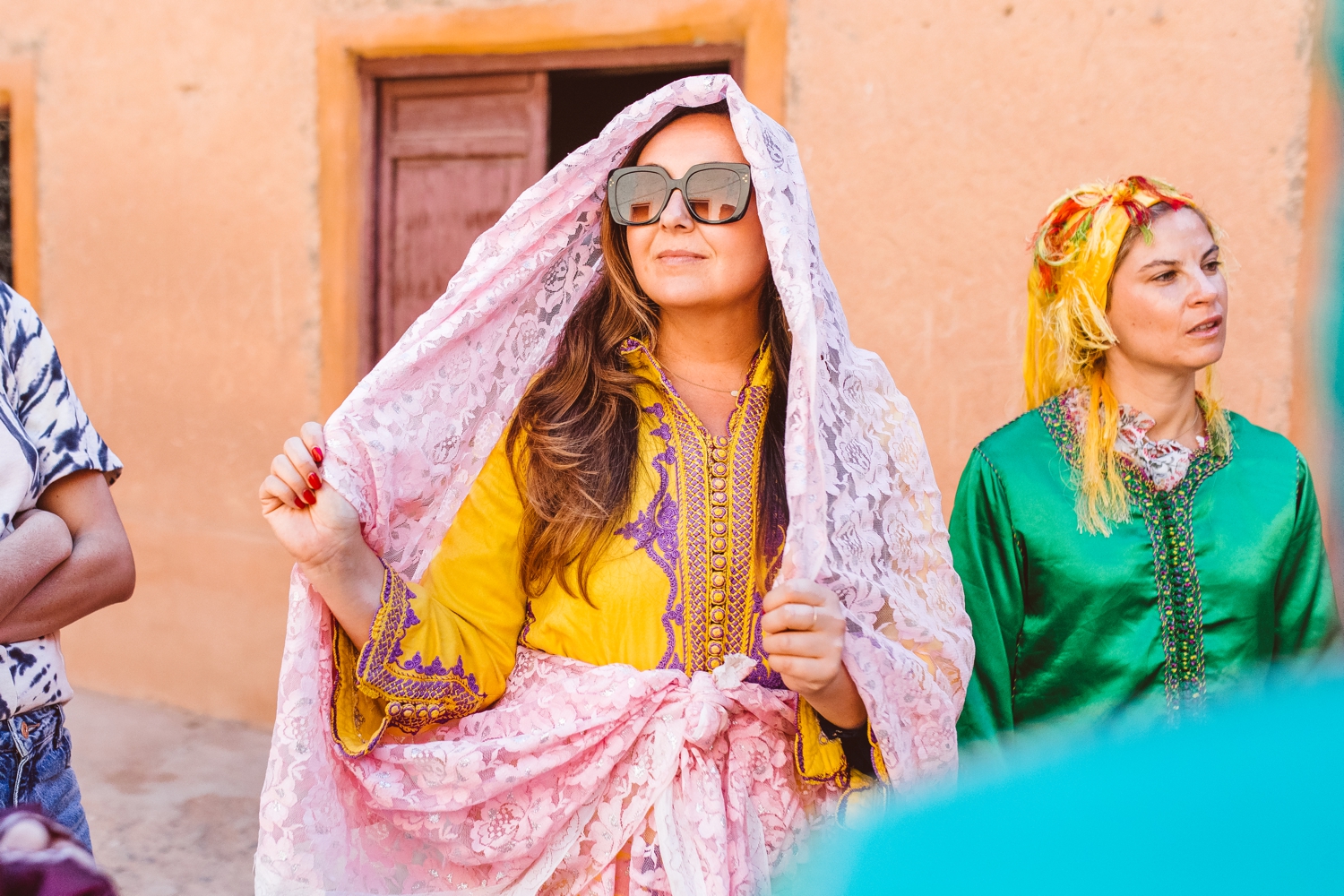 Woman wearing yellow Moroccan outfit with pink lace head covering in Marrakesh, Morocco | Brooke Michelle Photography