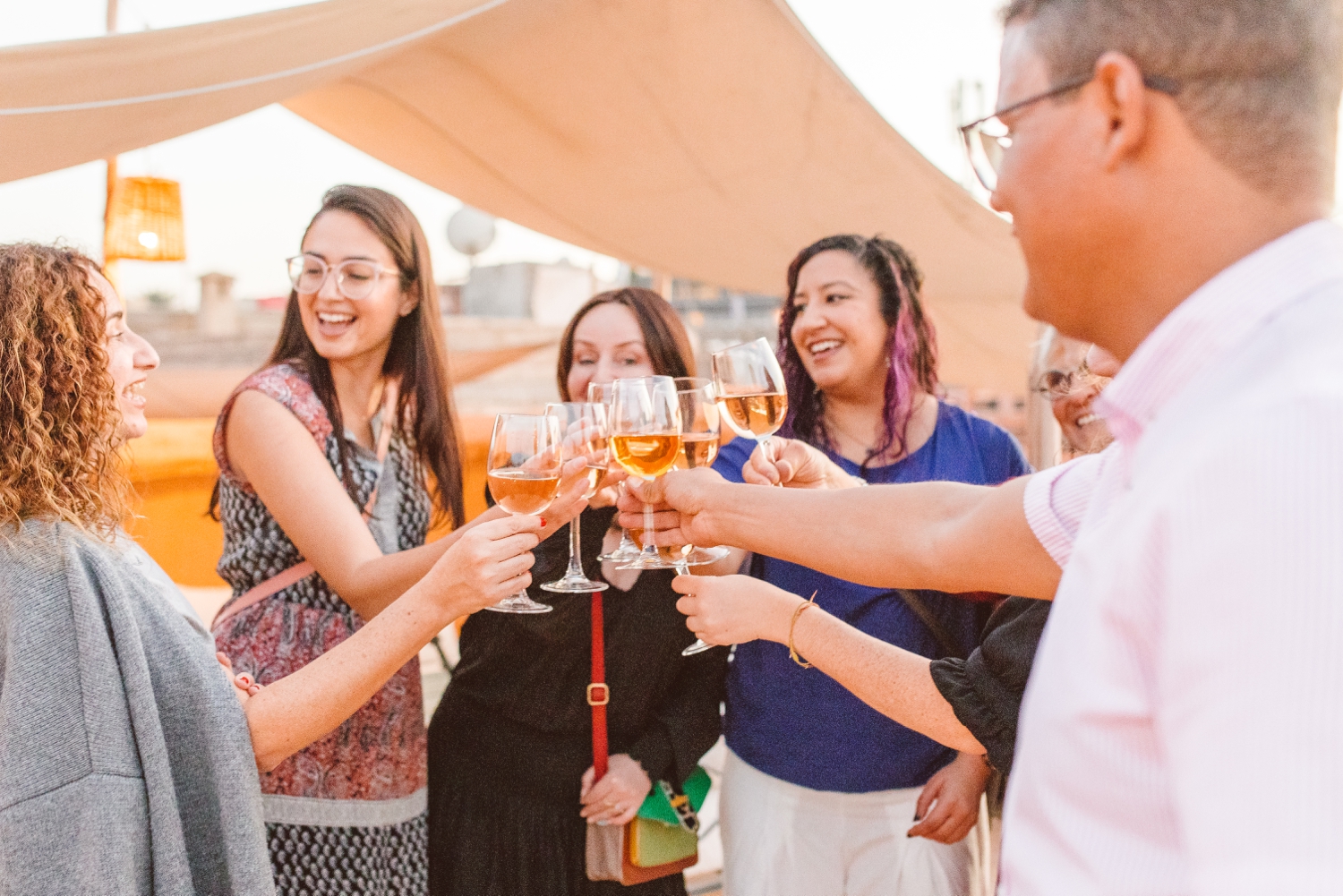 Group of women doing cheers with welcome drinks as part of group trip to Marrakesh, Morocco with travel photographer documenting moment | Brooke Michelle Photography