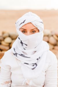 Woman wearing white head and face covering in Afgay Desert in Morocco | Brooke Michelle Photography