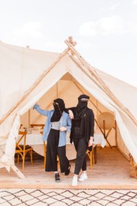 Photo taken by travel photographer of women wearing head and face coverings standing in tent in Afgay Desert | Brooke Michelle Photography