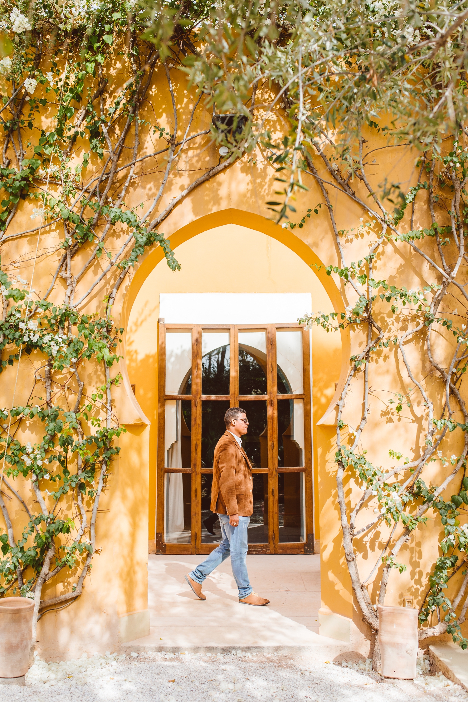 Man walking by arched door covered in ivy in Marrakesh, Morocco | Brooke Michelle Photography