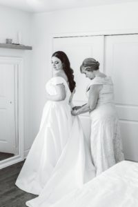 Mom buttoning up bride's dress | Brooke Michelle Photo