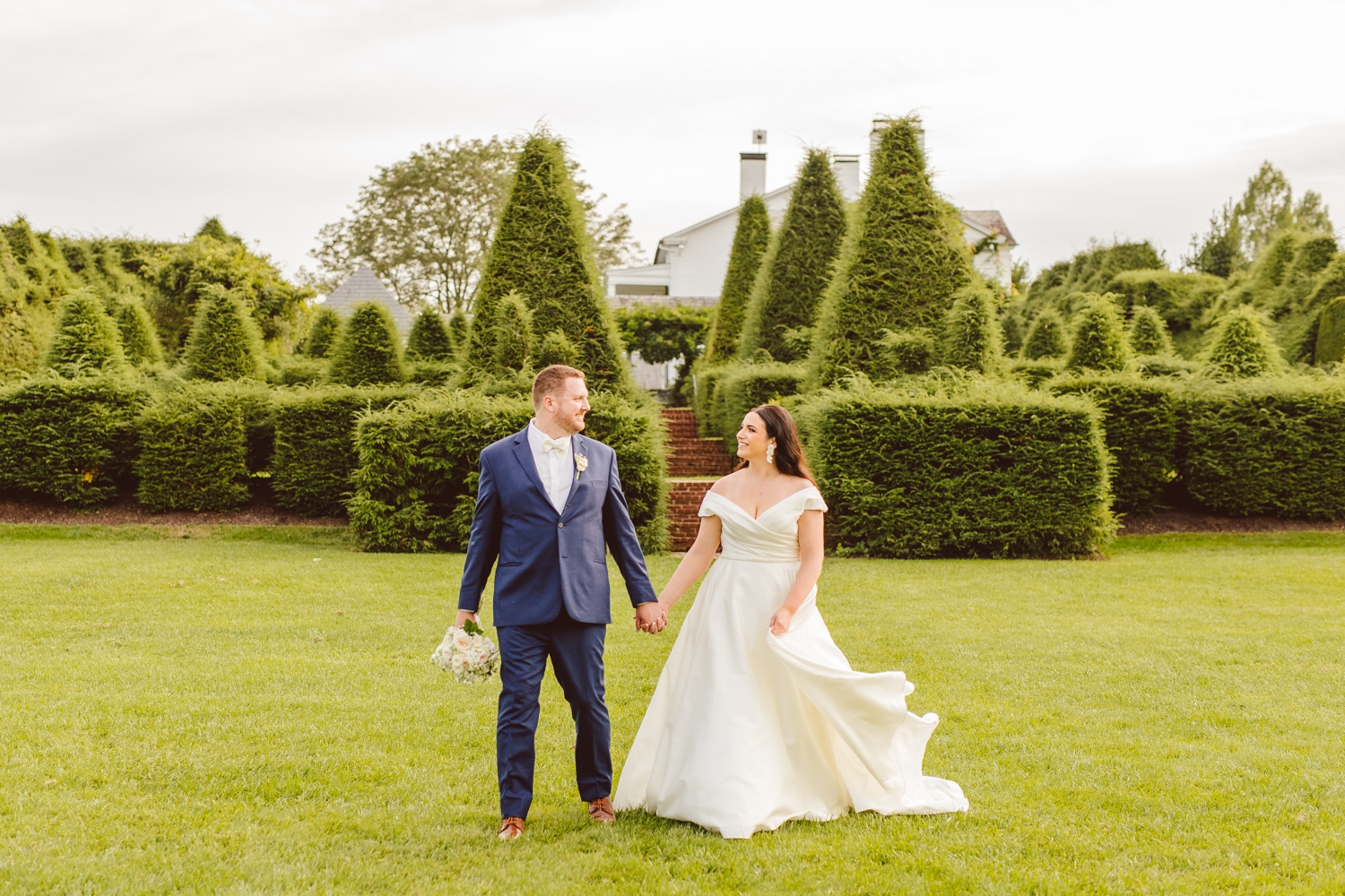 Bride and groom holding hands and walking at Ladew Topiary Gardens wedding | Brooke Michelle Photo