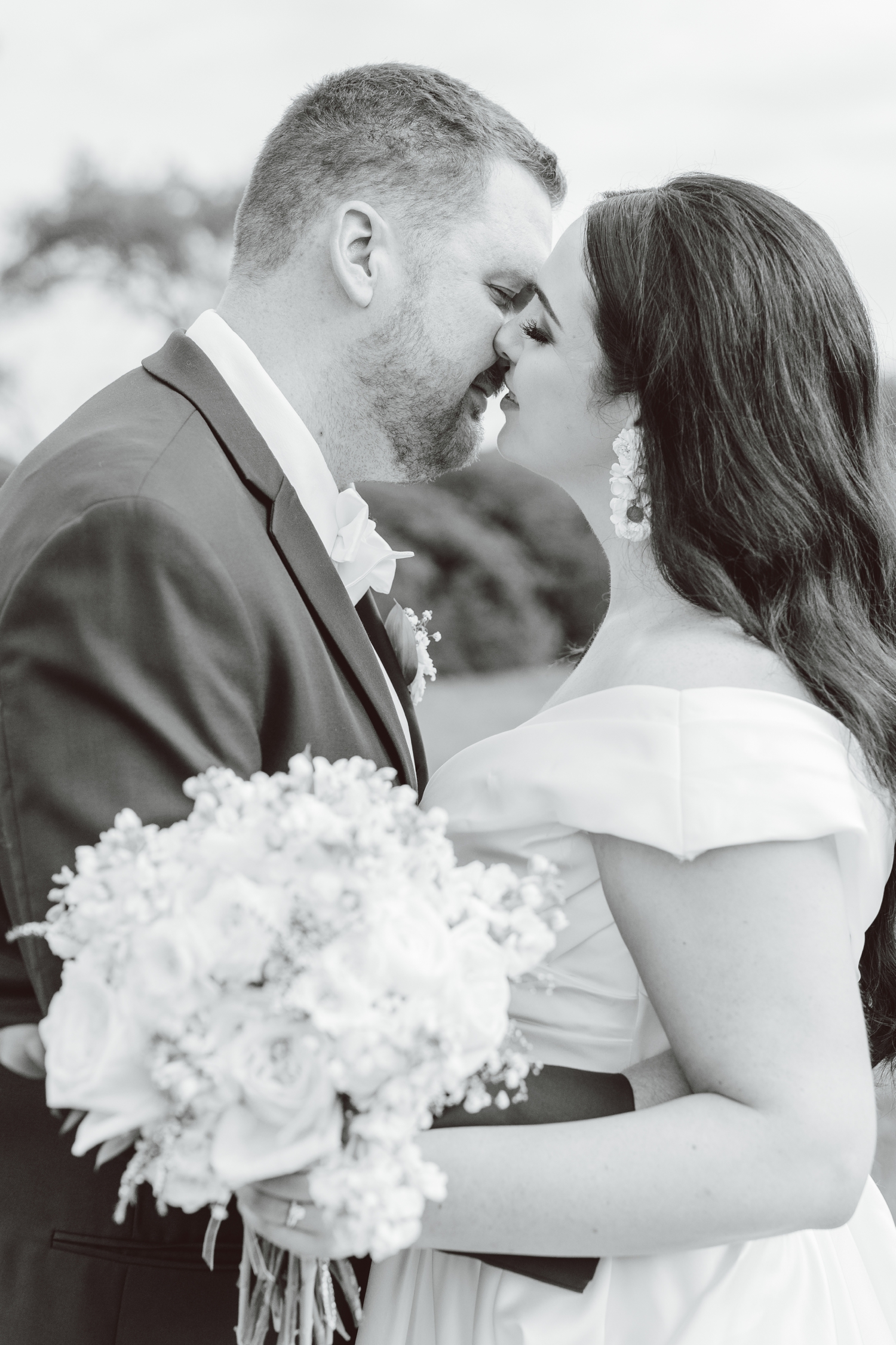 Bride and groom kissing while bride holds bouquet at Ladew Topiary Gardens | Brooke Michelle Photo