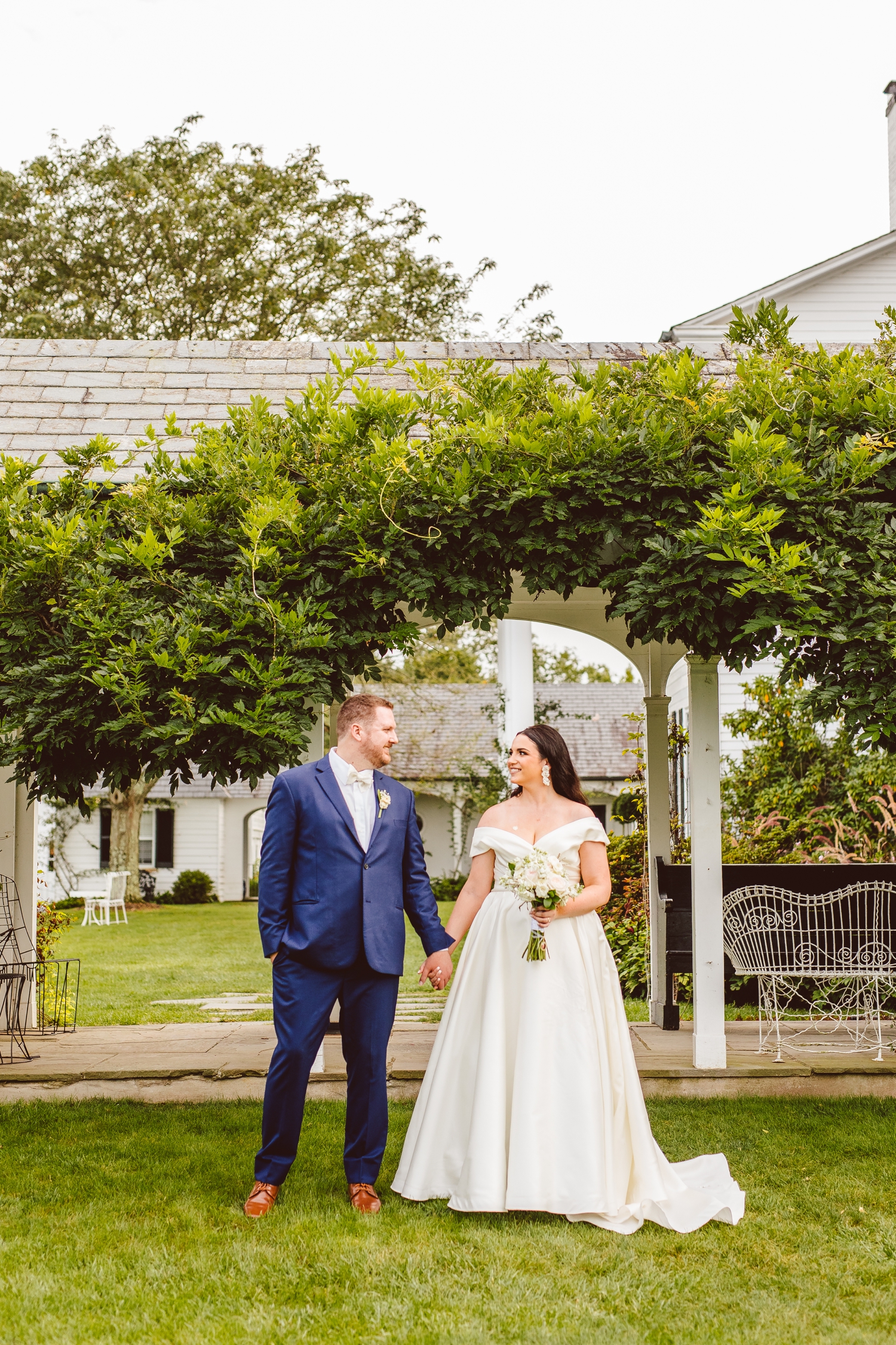 Bride and groom standing in Ladew Topiary Gardens while holding hands | Brooke Michelle Photo