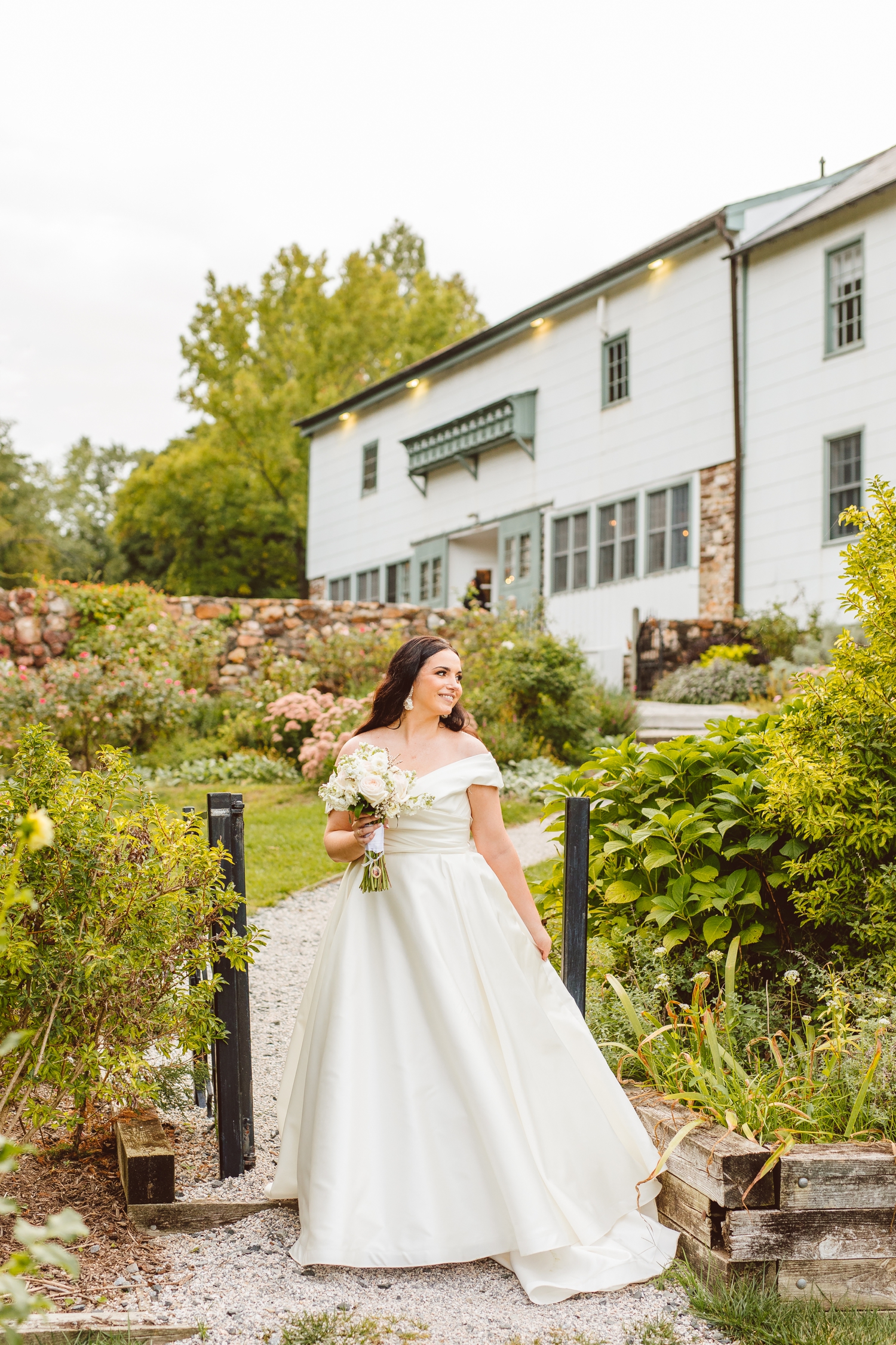 Bride walking in front of flowers at Ladew Topiary Gardens | Brooke Michelle Photo