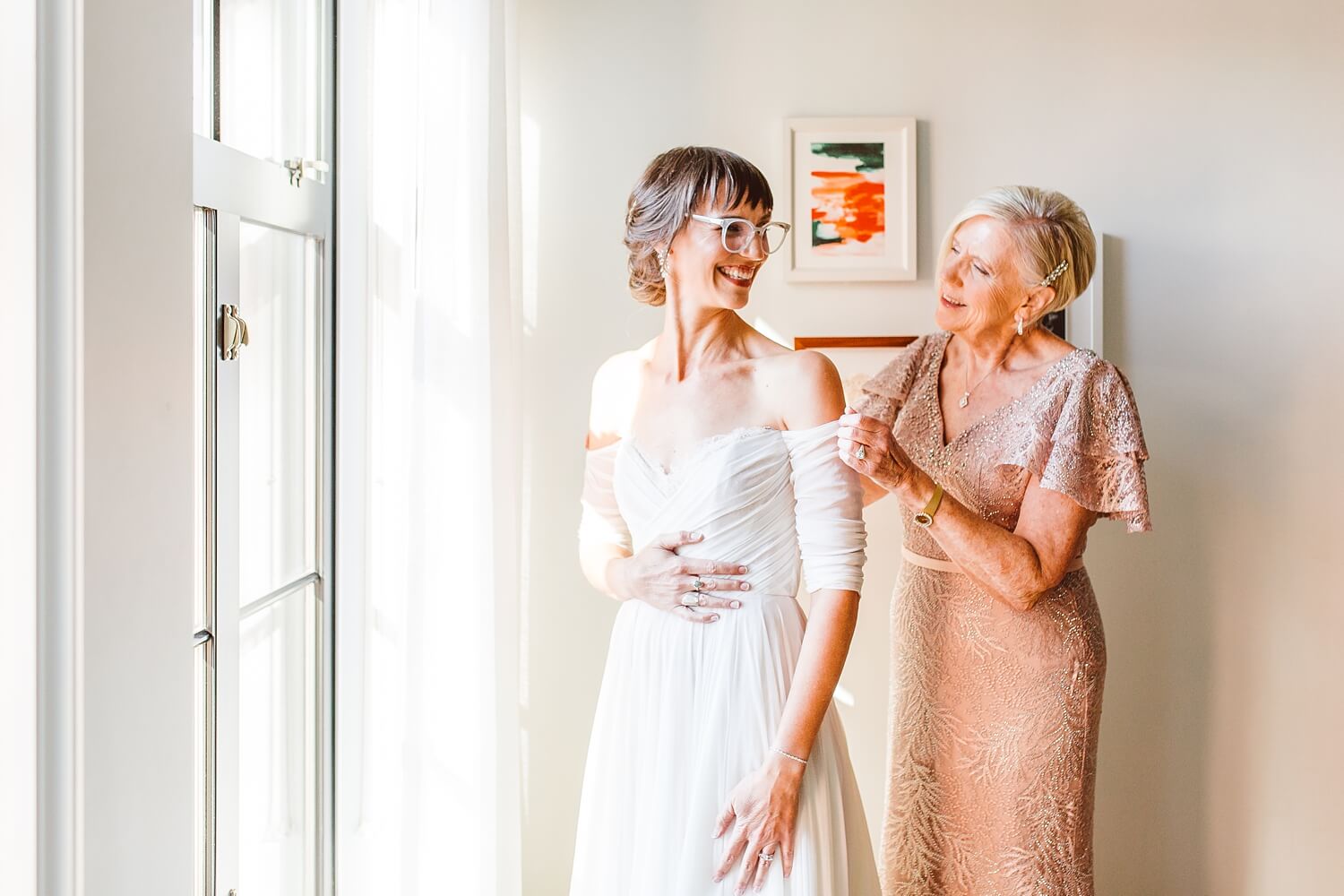 Mom helping bride put on dress while getting ready for wedding at The LINE DC | Brooke Michelle Photography