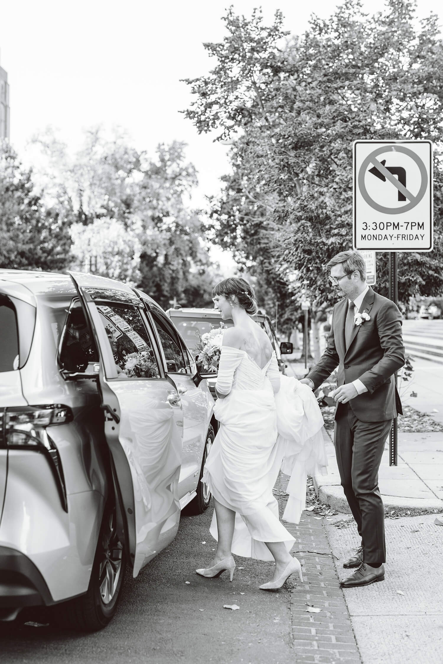 Groom helping bride into car after wedding ceremony | Brooke Michelle Photography