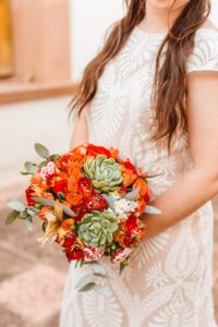 Bride holding red bouquet with succulents | Brooke Michelle Photo