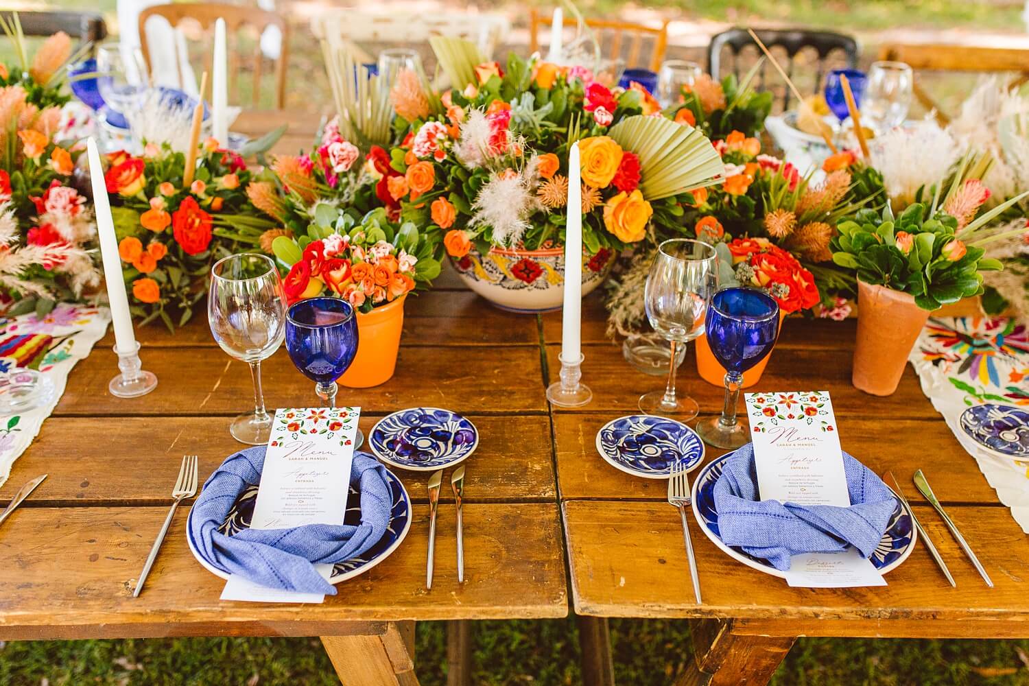 Colorful floral centerpieces with blue and white plates at wedding reception | Brooke Michelle Photo