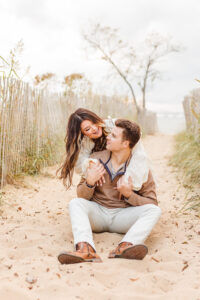 Couple posing for romantic engagement engagement photoshoot beach session