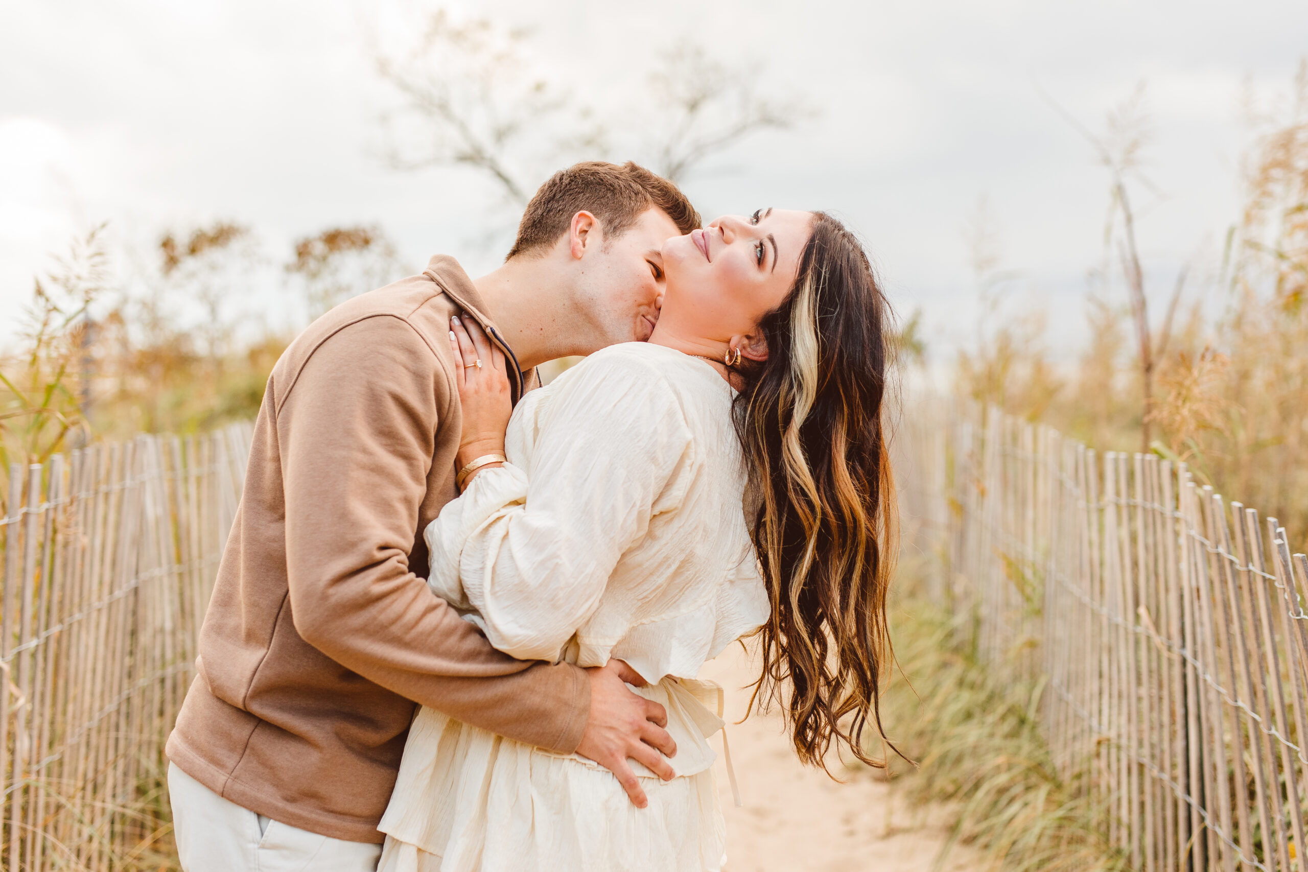 Couple posing for romantic engagement engagement photoshoot beach session
