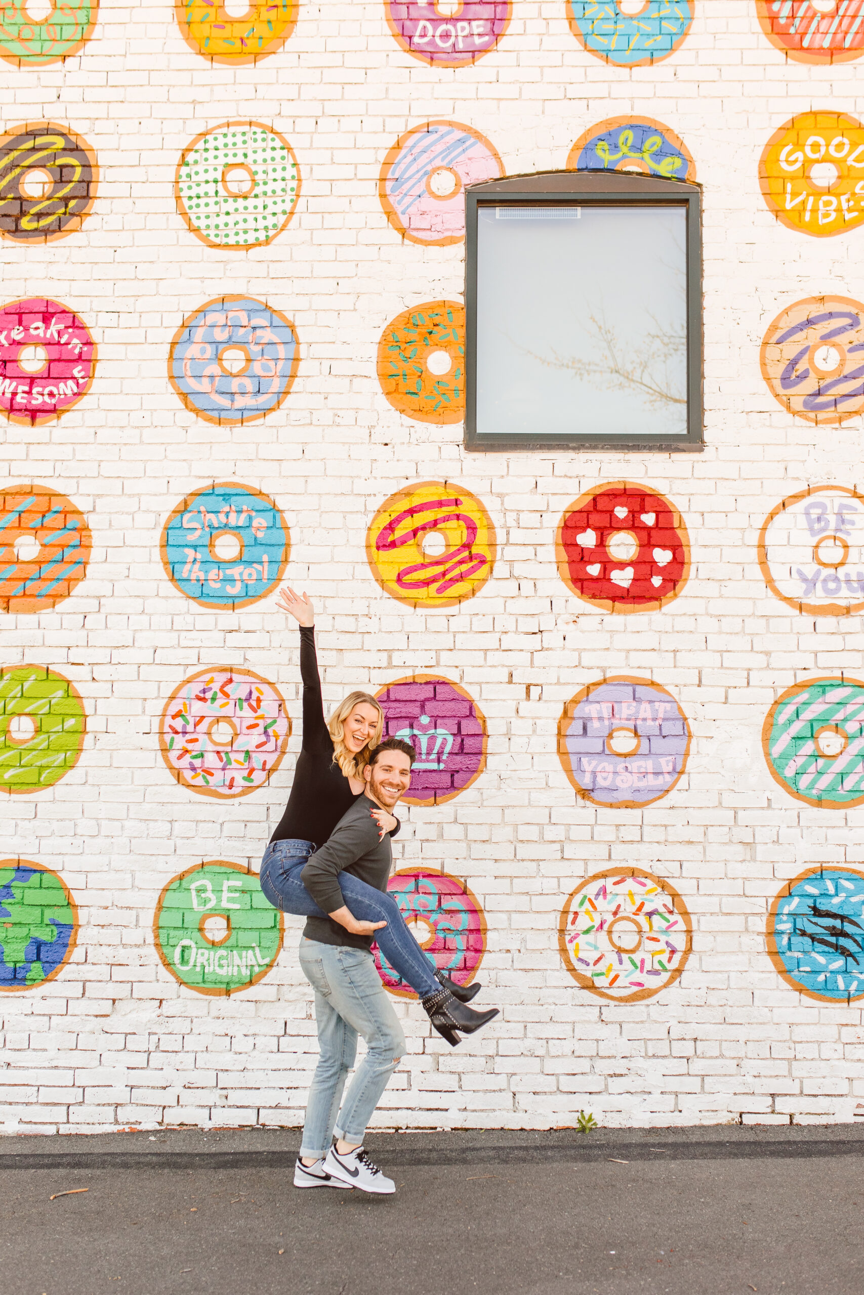 Dre Charlotte Influencer posing in front of Donut Wall 6. Donut Wall by Gina Elizabeth Franco at 2116 Hawkins St - Best Murals in Charlotte North Carolina