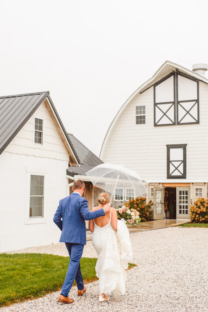 Bride and groom rainy wedding day portraits with clear umbrellas