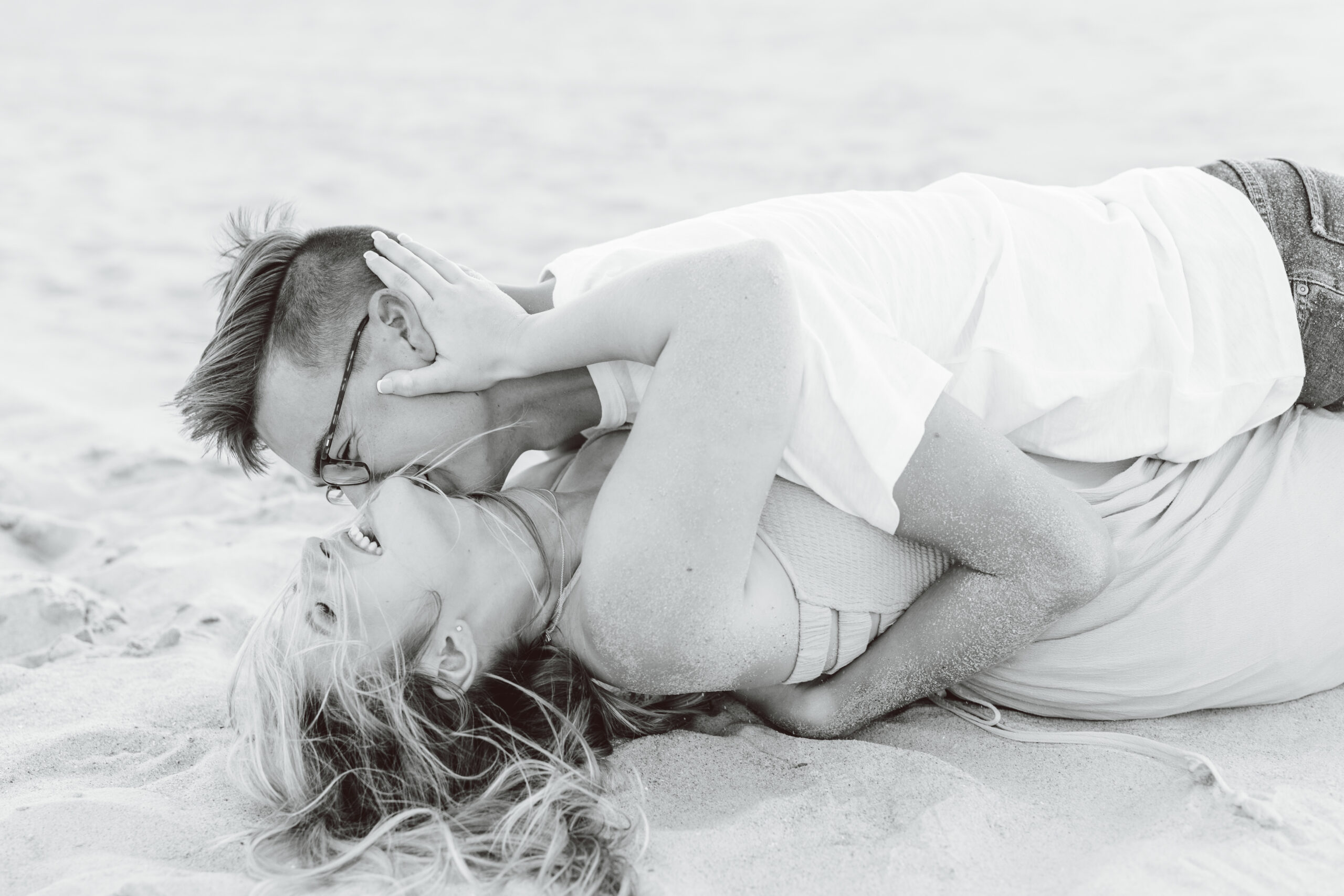 Couple rolling around on the beach
