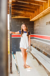 senior posing at the camera at her high school softball fields