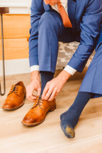 groom putting his shoes on before the ceremony