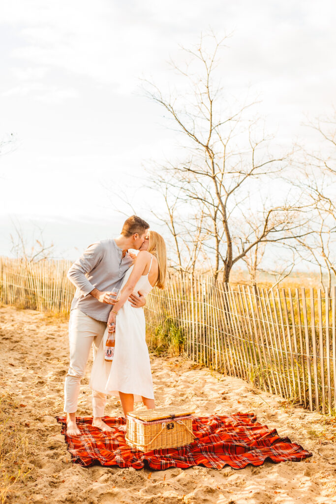 newly engaged couple kissing at their picnic engagement session