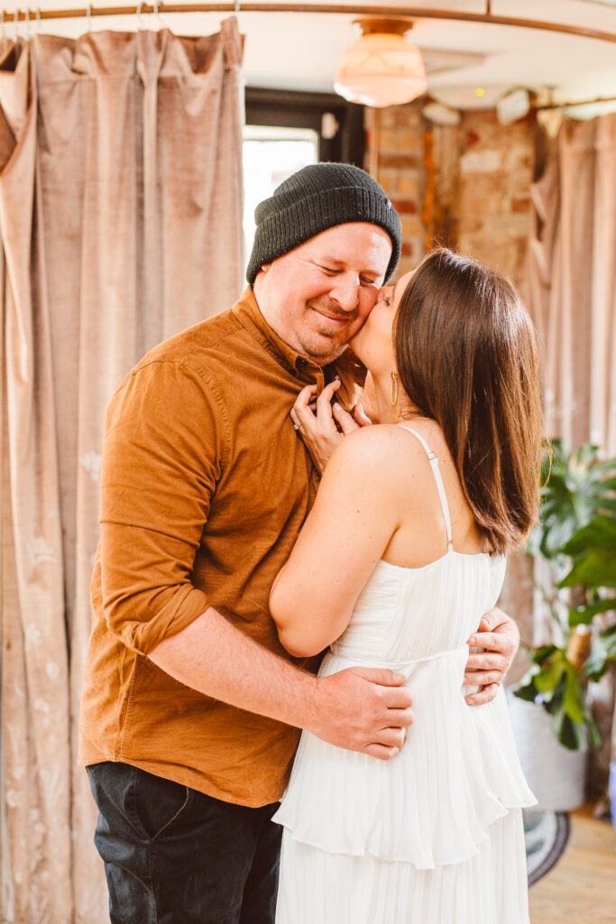 fiance kissing her fiance on the cheek at their romantic & vibrant engagement session