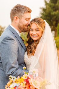 groom kissing the bride on the forehead