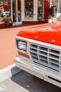 Close-up detail of a vintage red Ford pickup grille outside The Walmart Museum in downtown Bentonville, Arkansas